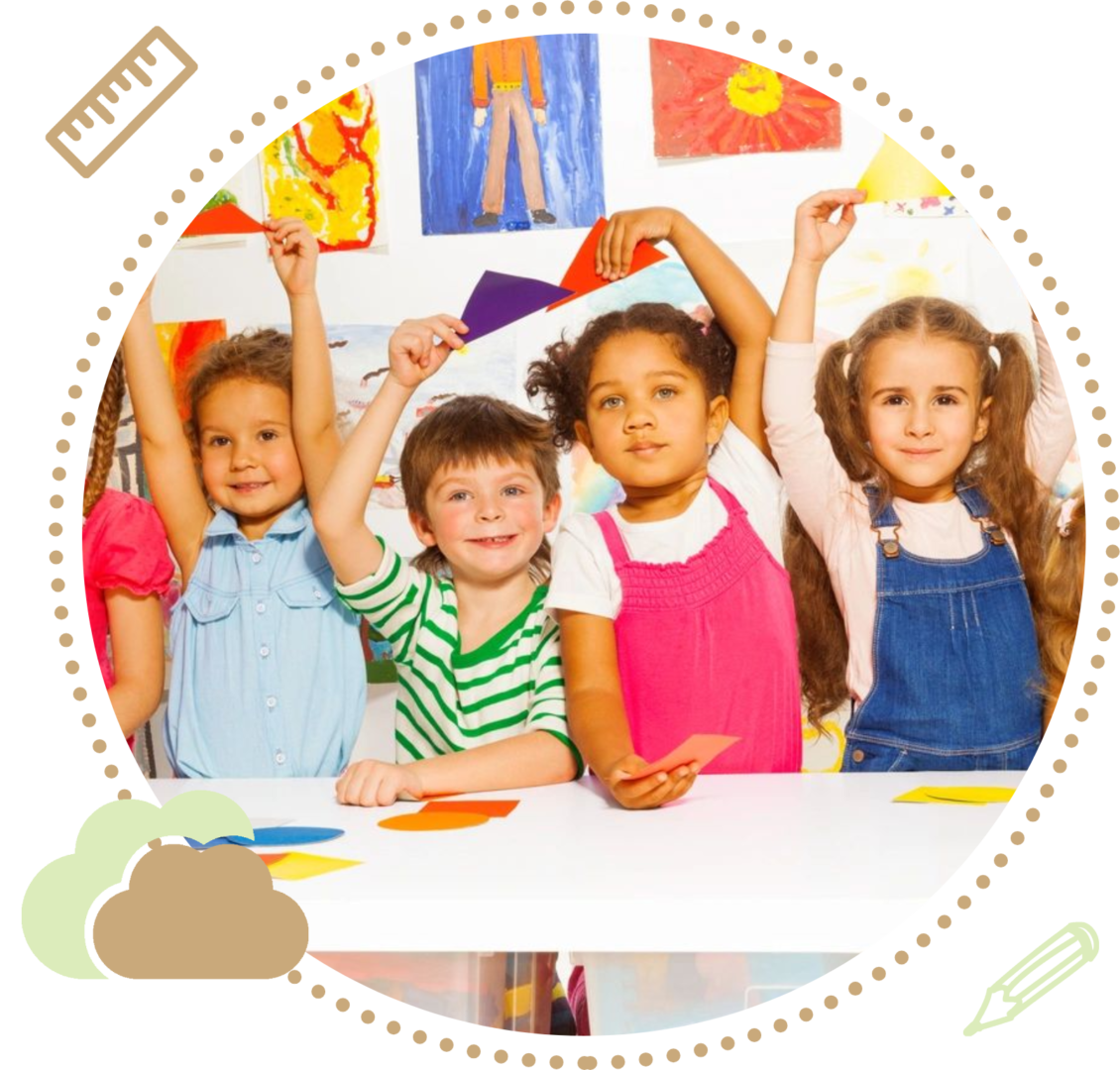 A group of Preschool children sitting at a table with their hands raised.