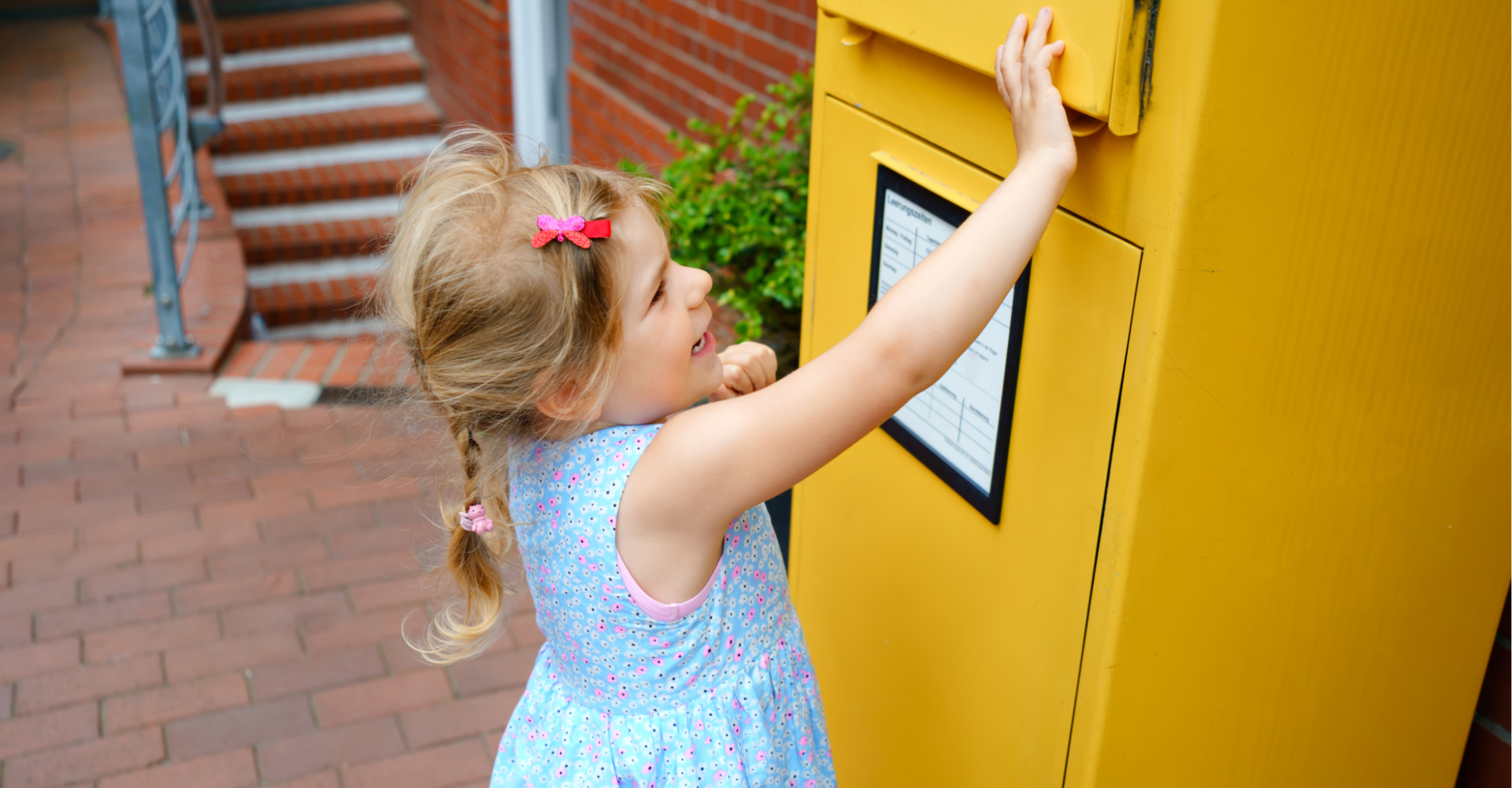 A little girl putting money in an envelope.