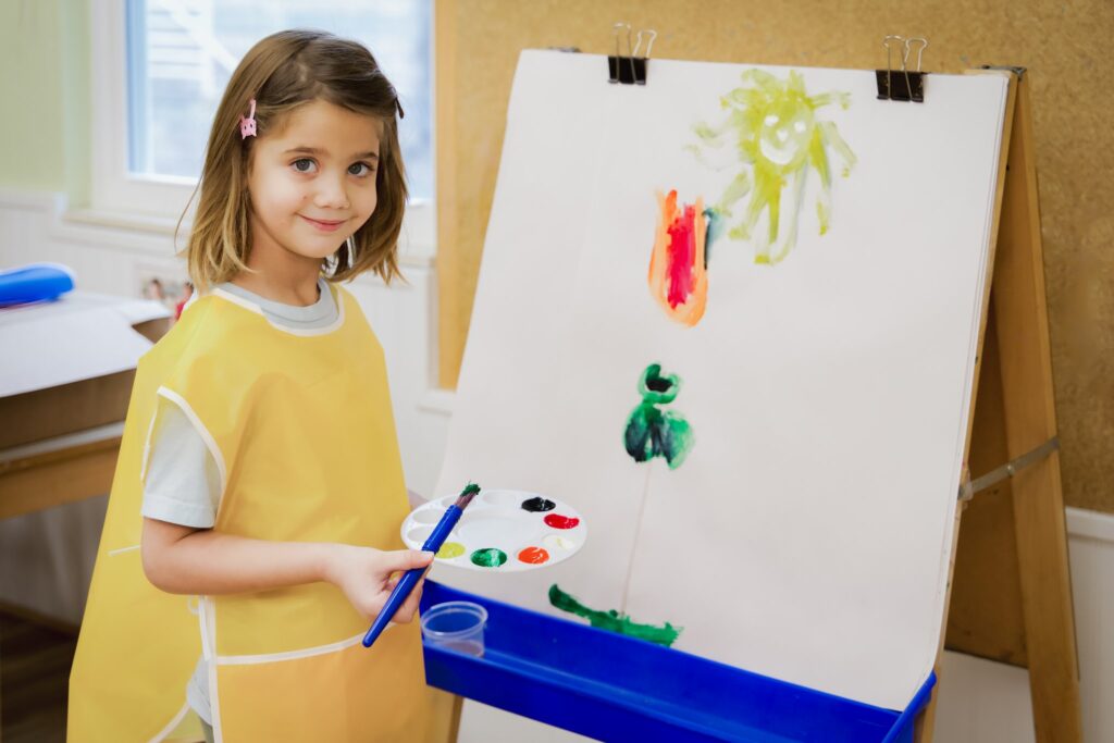 A Preschool child painting their curriculum