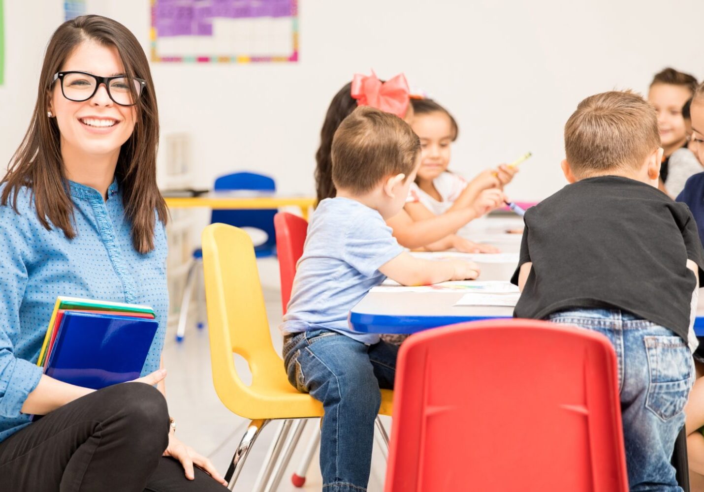 A woman sitting at a table with children.